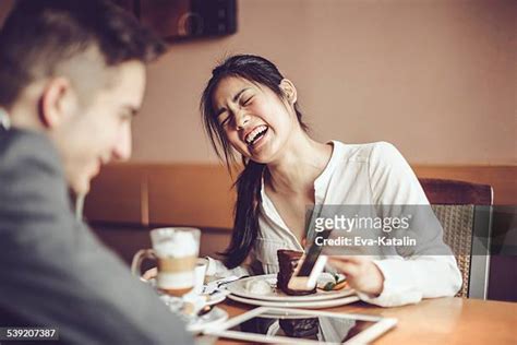 Young men and women meeting at cafe table and using cell phone man eating out woman pictures stock pictures, royalty-free photos & images Friends sharing some photos on mobile phone Group of young people sitting in a cafe and looking at the photos on smart phone.